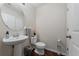 Cozy bathroom features a stylish round mirror and a modern pedestal sink at 3508 Brighton Park Cir, Belle Isle, FL 32812