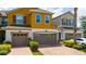 Two-story townhouse featuring an attached garage and a brick paved driveway at 3508 Brighton Park Cir, Belle Isle, FL 32812