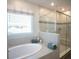 Modern bathroom with a soaking tub and glass-enclosed shower, designed for relaxation and style at 351 S Sunset Ave, Mascotte, FL 34753