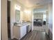 Bathroom showcasing double sinks and vanity with a bathtub and open doorway into the bedroom at 351 S Sunset Ave, Mascotte, FL 34753