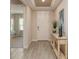 Inviting entryway with light wood floors, neutral walls, tray ceiling, and a decorative console table at 351 S Sunset Ave, Mascotte, FL 34753