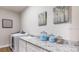 Functional laundry room with granite countertops, a sink, and a modern washing machine at 351 S Sunset Ave, Mascotte, FL 34753