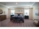 Spacious main bedroom with a tray ceiling, carpeted floors, and dual nightstands next to the bed at 351 S Sunset Ave, Mascotte, FL 34753