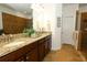 Bathroom featuring a granite vanity with double sinks, walk-in shower, and coastal decor at 3574 La Jolla Dr, Clermont, FL 34711