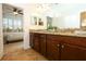 Bathroom featuring a granite vanity with double sinks and a window at 3574 La Jolla Dr, Clermont, FL 34711