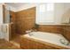 Bathroom with a soaking tub, tiled shower, and plantation shutters at 3574 La Jolla Dr, Clermont, FL 34711