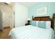 Bedroom featuring a blue accent wall, plantation shutters, and wooden bed frame at 3574 La Jolla Dr, Clermont, FL 34711