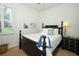 Bedroom featuring a black bed frame, a window with plantation shutters, and a nightstand at 3574 La Jolla Dr, Clermont, FL 34711