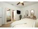 Bedroom with neutral decor, ceiling fan, large mirror, and access to the Primary bathroom at 3574 La Jolla Dr, Clermont, FL 34711