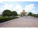 Community entrance with a charming gatehouse, manicured landscaping, and brick-paved road at 3574 La Jolla Dr, Clermont, FL 34711