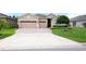 Charming home featuring a brick driveway, a two car garage, manicured lawn, and neatly trimmed bushes at 3574 La Jolla Dr, Clermont, FL 34711
