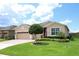 Inviting single-story home featuring manicured lawn, neat landscaping, and a charming, neutral color scheme at 3574 La Jolla Dr, Clermont, FL 34711