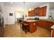 Kitchen area featuring wood cabinets, an island with seating, and stainless steel appliances at 3574 La Jolla Dr, Clermont, FL 34711