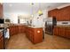 Spacious kitchen featuring granite countertops, wood cabinets, stainless steel appliances, and tile flooring at 3574 La Jolla Dr, Clermont, FL 34711