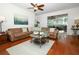 Cozy living room featuring hardwood floors, a sectional sofa, and sliding glass doors to the lanai at 3574 La Jolla Dr, Clermont, FL 34711