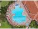 Aerial view of a uniquely shaped pool with plenty of lounge seating and manicured landscaping at 3574 La Jolla Dr, Clermont, FL 34711