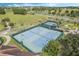 Aerial view of community tennis courts, with lush greenery and palm trees around the perimeter at 3574 La Jolla Dr, Clermont, FL 34711