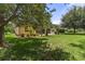 Beautiful backyard offering mature trees, palm trees and green lawn, providing a private outdoor oasis at 3637 Foxchase Dr, Clermont, FL 34711