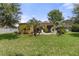 Well-maintained backyard with manicured lawn, palm trees, and a patio perfect for relaxation or entertaining at 3637 Foxchase Dr, Clermont, FL 34711