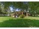 Spacious backyard featuring lush green grass, mature trees, and a patio area perfect for outdoor entertaining at 3637 Foxchase Dr, Clermont, FL 34711