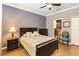 Cozy bedroom with hardwood floors, neutral paint, and a view into the ensuite bathroom at 3637 Foxchase Dr, Clermont, FL 34711