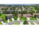 Aerial view of a home with a well-manicured front yard in a residential neighborhood with sidewalks at 3637 Foxchase Dr, Clermont, FL 34711