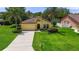 Charming single-story home featuring lush landscaping, a well-manicured lawn, and a classic stucco facade at 3637 Foxchase Dr, Clermont, FL 34711