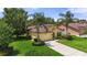 Charming single-story home featuring lush landscaping, a well-manicured lawn, and a classic stucco facade at 3637 Foxchase Dr, Clermont, FL 34711