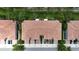 Drone shot capturing multiple townhomes with red tiled roofs, driveways, and tree-lined street at 366 Reed Grass Dr, Oviedo, FL 32765