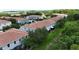 Aerial view of modern townhomes with green grass, trees, landscaping, and street parking at 366 Reed Grass Dr, Oviedo, FL 32765
