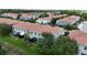 Aerial view of townhomes with terracotta roofs, lush trees, and maintained lawns in the community at 366 Reed Grass Dr, Oviedo, FL 32765