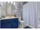 Cozy bathroom with blue vanity, shelving decor, decorative mirror, and stylish patterned shower curtain at 366 Reed Grass Dr, Oviedo, FL 32765
