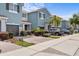 View of a row of charming blue townhomes, each with a private garage and beautiful landscaping at 366 Reed Grass Dr, Oviedo, FL 32765