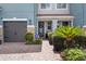 Close up of townhome exterior with a private garage, stone accents, and beautiful landscaping at 366 Reed Grass Dr, Oviedo, FL 32765