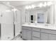 Modern bathroom with double vanity, sleek grey cabinetry, and glass-enclosed shower at 378 Cape Honeysuckle Pl, Sanford, FL 32771