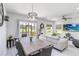 Bright and open living space with dining area, water view, modern furniture, and sliding glass doors to the patio at 378 Cape Honeysuckle Pl, Sanford, FL 32771