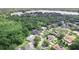 An aerial view captures this lushly landscaped home nestled amongst mature trees near a tranquil lake at 4048 Gilder Rose Pl, Winter Park, FL 32792