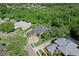 Aerial view of a beautifully landscaped home with a circular driveway nestled amongst mature trees at 4048 Gilder Rose Pl, Winter Park, FL 32792