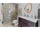 Updated bathroom featuring a glass shower, dark wood vanity with a white countertop, and a unique wooden-framed mirror at 4048 Gilder Rose Pl, Winter Park, FL 32792