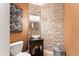 Chic half-bathroom features a stone accent wall, modern vanity with glass bowl sink, and stylish fixtures at 4048 Gilder Rose Pl, Winter Park, FL 32792