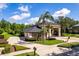 Beautiful home with a circular driveway, manicured lawn, lush landscaping, and towering palm trees at 4048 Gilder Rose Pl, Winter Park, FL 32792