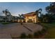Stately exterior view of home with circular driveway, manicured lawn, and towering palm trees at 4048 Gilder Rose Pl, Winter Park, FL 32792