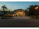 Stately exterior view of home with circular driveway, porte-cochere, manicured lawn, and towering palm trees at 4048 Gilder Rose Pl, Winter Park, FL 32792