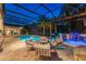 Twilight view of the pool area featuring an outdoor kitchen, ample seating, and lush landscaping offering a serene atmosphere at 4048 Gilder Rose Pl, Winter Park, FL 32792