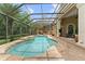 This screened pool area features stone accents, an outdoor fireplace, and multiple seating areas at 4048 Gilder Rose Pl, Winter Park, FL 32792