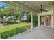 A charming covered back porch features a ceiling fan and overlooks a lush backyard at 408 W Pearl St, Minneola, FL 34715