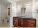 Bathroom with a dark wood vanity, tiled backsplash, and access to a private toilet at 408 W Pearl St, Minneola, FL 34715