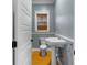 Stylish powder room features a pedestal sink, toilet, and window with bamboo shades at 408 W Pearl St, Minneola, FL 34715