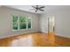 Sunlit bedroom with hardwood floors and a large window with views of lush greenery at 408 W Pearl St, Minneola, FL 34715