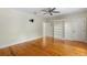 Bedroom featuring a ceiling fan, hardwood floors, and a built-in bookshelf with abundant storage at 408 W Pearl St, Minneola, FL 34715